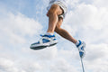 Athlete jumping in CUVS Whiteout track spike covers over blue sprint spikes outdoors.